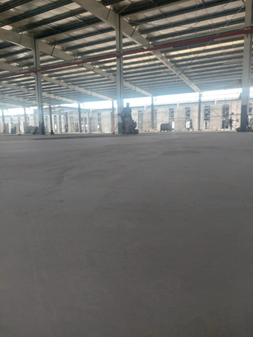 Progres jasa epoxy lantai dengan permukaan basah dan reflektif saat tahap penghalusan atau self-leveling.
